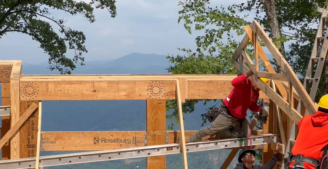Construction workers high up on wood frame